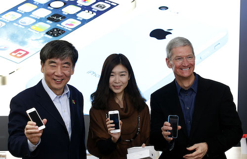 China Mobile's Chairman Xi Guohua (L), Apple Inc. CEO Tim Cook (R) and a customer pose with Apple iPhones at an event celebrating the launch of Apple's iPhone on China Mobile's network at a China Mobile shop in Beijing January 17, 2014. Apple Inc is finally launching its iPhone on China Mobile Ltd's vast network on Friday, opening the door to the world's largest carrier's 763 million subscribers and giving its China sales a short-term jolt. REUTERS/Kim Kyung-Hoon (CHINA - Tags: BUSINESS TELECOMS)